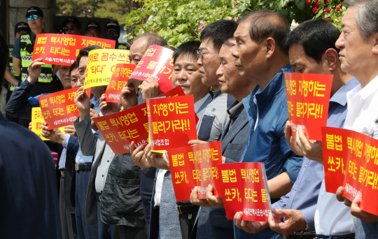 서울개인택시운송사업조합 관계자들이 지난달 서울 서초구 서울중앙지검 인근에서 '타다' 불법운행 처벌 촉구 및 서울 개인택시 플랫폼 사업 실시 기자회견을 하고 있다.  연합뉴스